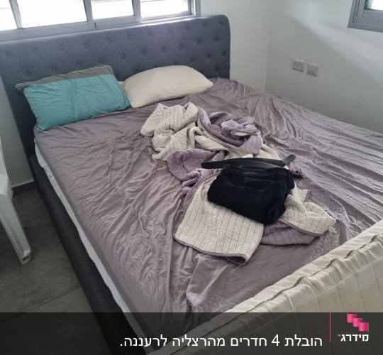 מיטה עם מצעים מבולגנים ותיק על המיטה